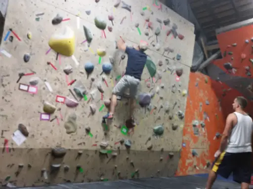 A person climbs a wall while another watches, showing how Mid State Baths in York, PA, makes sure every bathroom remodel is safe and carefully done.