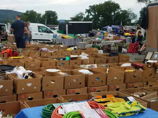 People browse an outdoor flea market, where services like Mid State Baths bathroom remodels can be found.