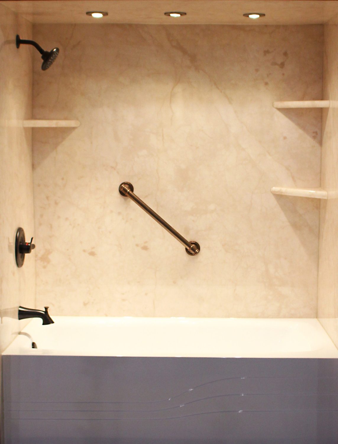 Mid State Baths shows a modern bathtub and shower design with shelves, grab bar, and safe lighting.